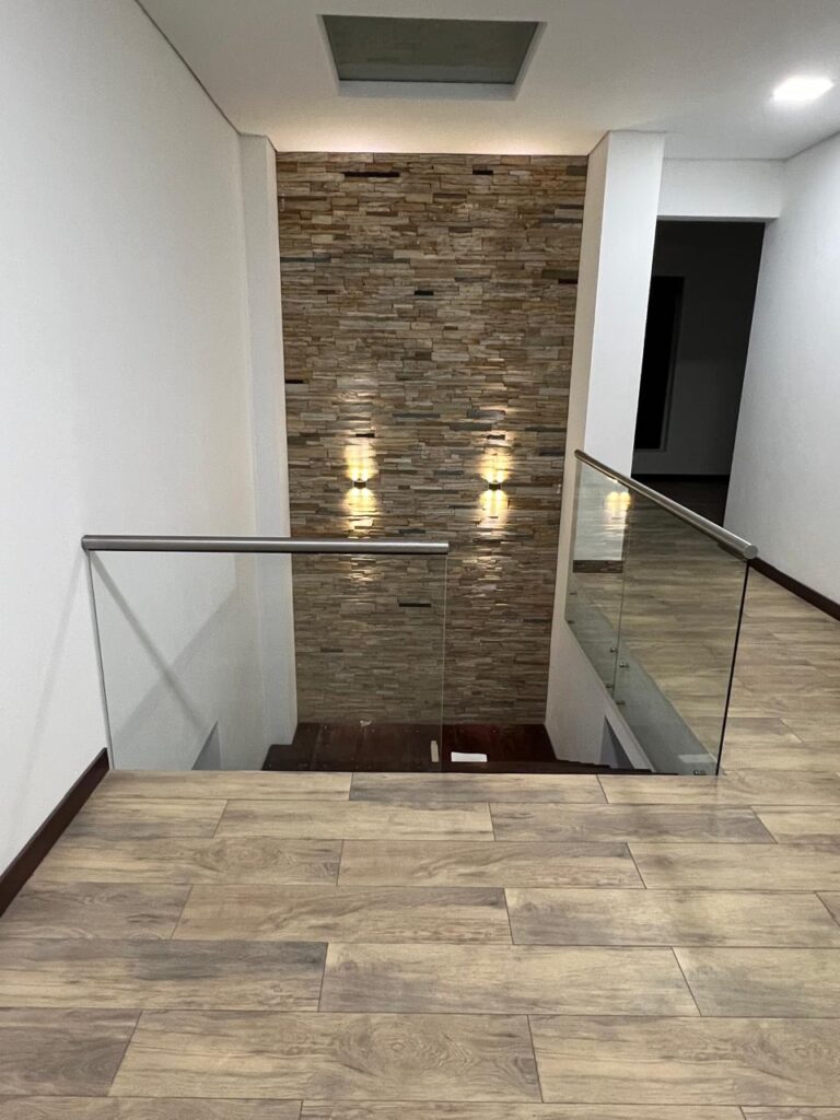Baranda en vidrio templado con pasamanos en acero inoxidable en vacío de escalera