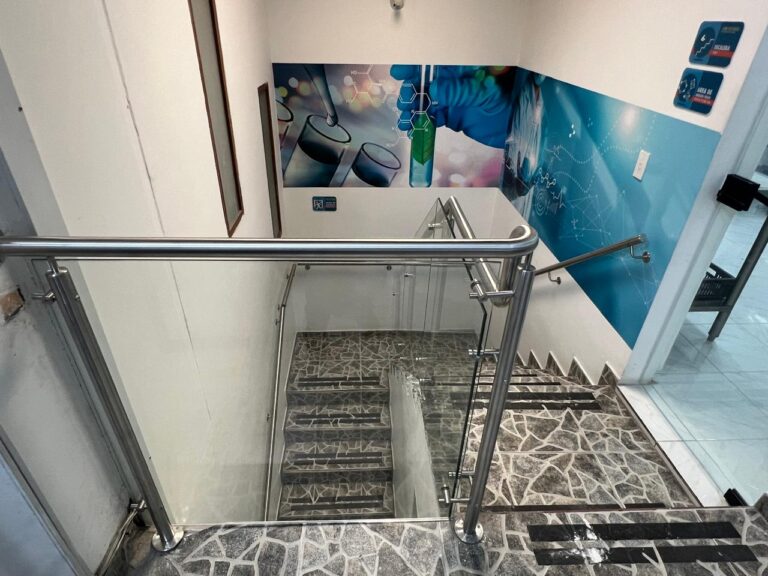 Baranda en acero inoxidable y vidrio alrededor de escalera interior