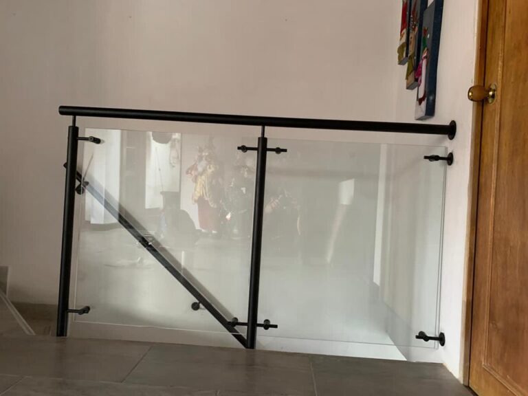 Baranda en vidrio templado con pasamanos negro en interior